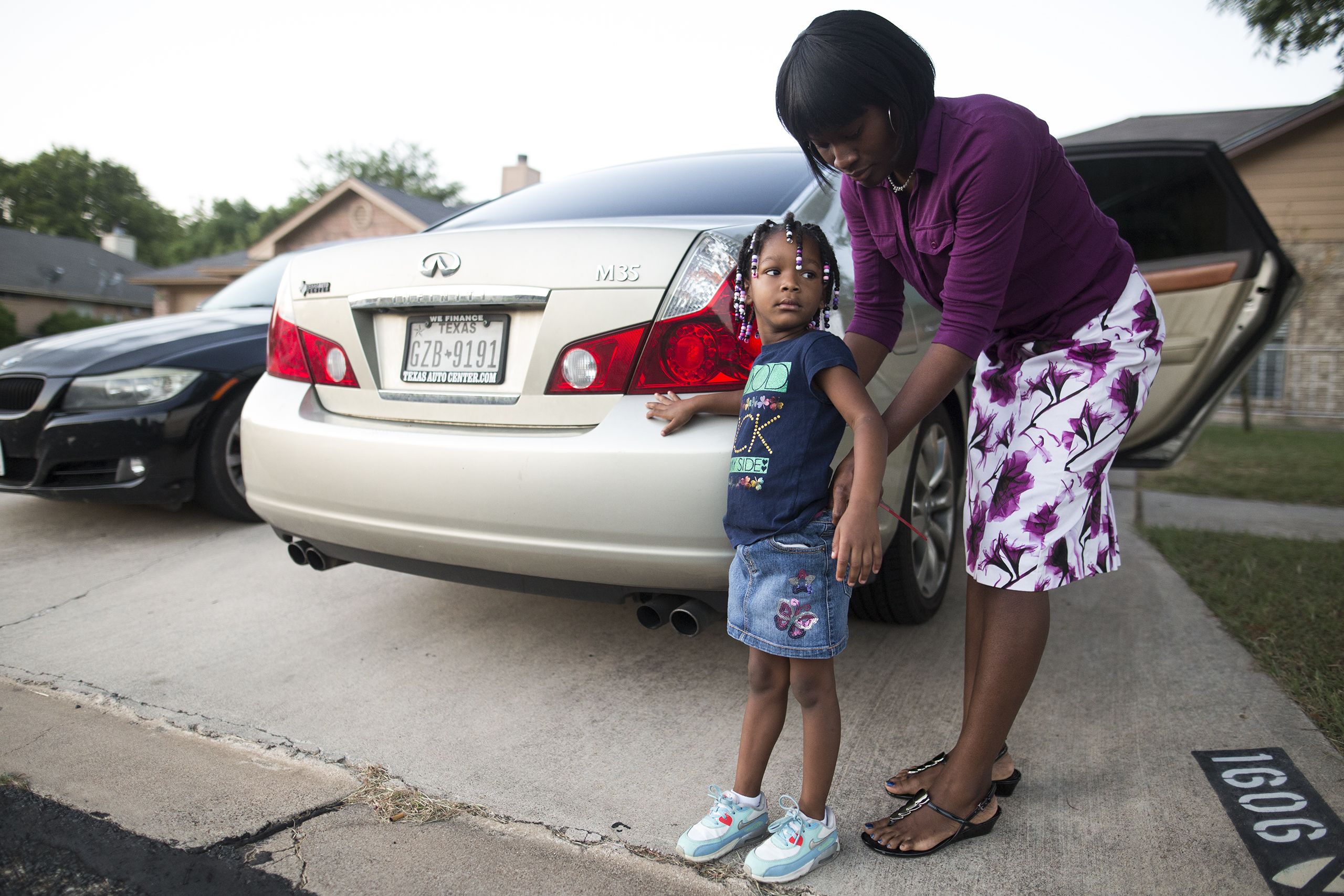 Brittany Phillips tucks in her daughter Leah's shirt before taking her to school.