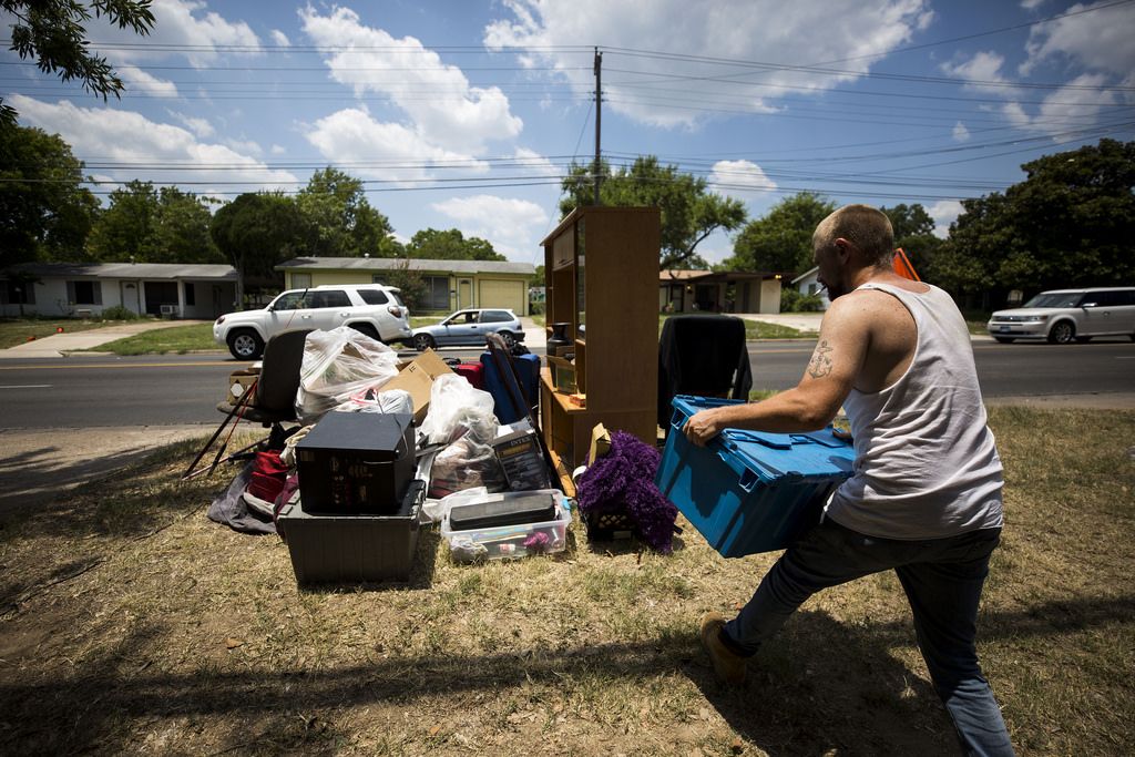 A man removes items from a home in Southwest Austin after residents were evicted.